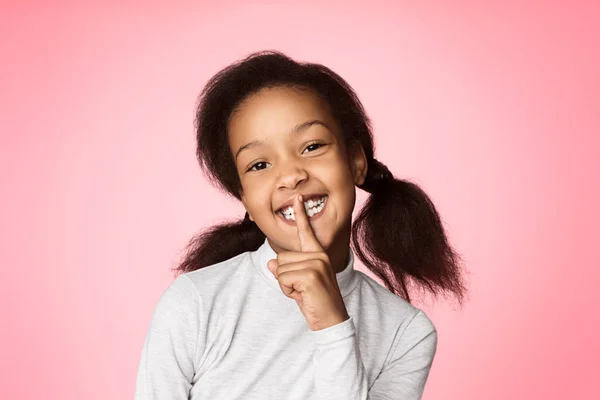 Držet v tajnosti. Afričan-americká dívka drží prst na ústa — Stock fotografie