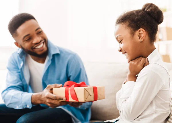 Padre afroamericano dando regalo a su hija en casa — Foto de Stock