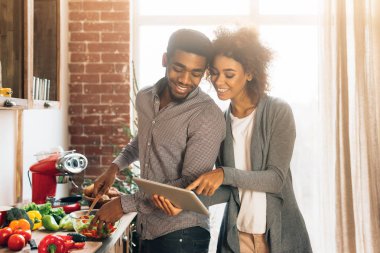 Genç siyah çift dijital tablet mutfakta kullanma