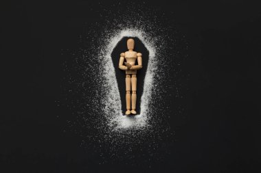 Wooden mannequin in coffin made of sugar on black clipart