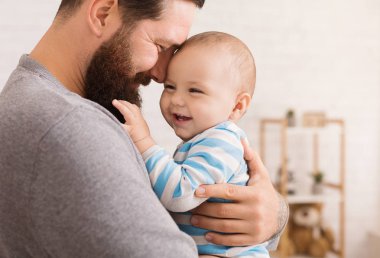 Sevgi dolu babası şirin bebek oğlu kucaklayan