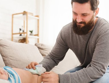 Memnun baba bebek evlat bezini değiştirme