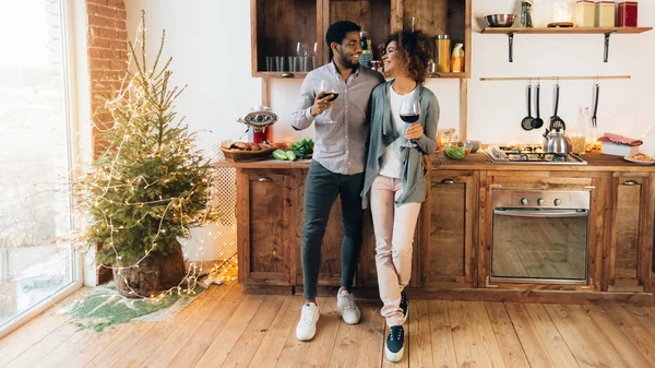 Молодая пара, празднующая Новый год, пьет вино на кухне — стоковое фото