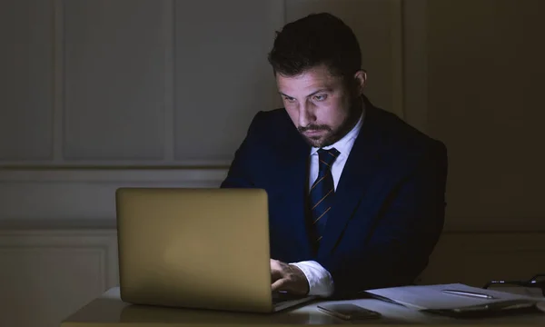 Uomo d'affari che lavora su laptop in ufficio scuro — Foto Stock