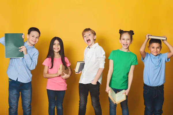 Kinder haben Spaß mit Büchern auf farbigem Hintergrund — Stockfoto