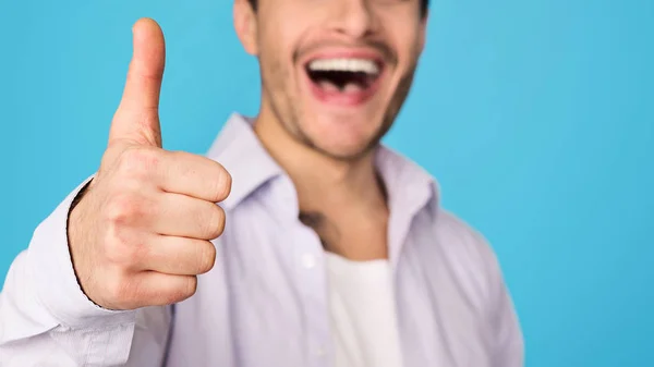 Задоволений чоловік показує великий палець вгору і посміхається — стокове фото