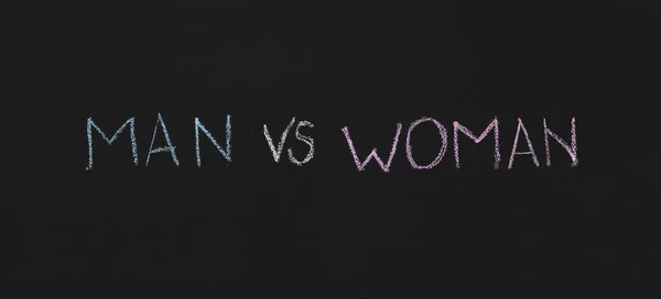 คําว่า Man vs Woman เขียนบนแผ่นจารึก — ภาพถ่ายสต็อก