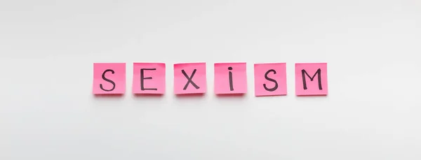Palavra SEXISM escrito em adesivos de escritório rosa — Fotografia de Stock