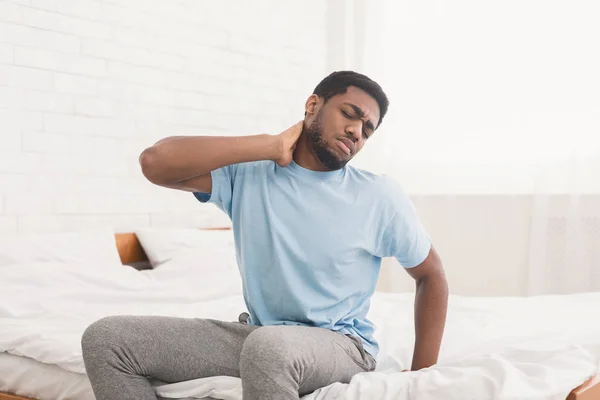 Hombre que sufre de dolor de espalda en casa en el dormitorio . — Foto de Stock