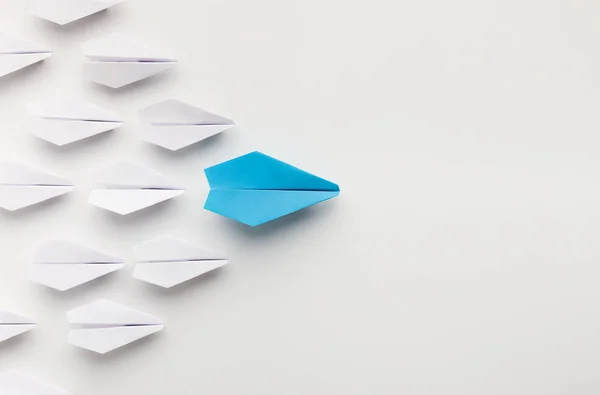 Ein blaues Papierflugzeug an der Spitze einer Gruppe weißer — Stockfoto