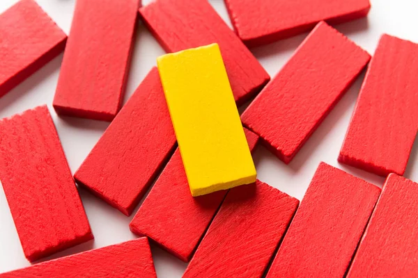 Jeden żółty blok drewniany na grupę czerwonych — Zdjęcie stockowe