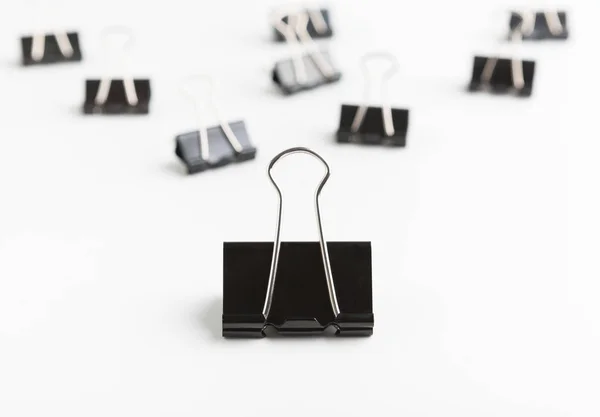 Big binder clip leading smaller ones on white background — Stock Photo, Image