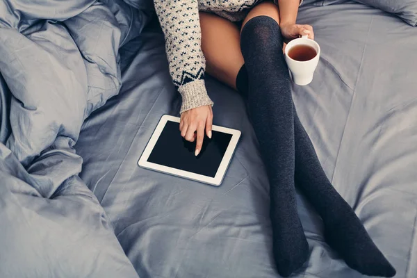 Genç kadın yatakta tablet ile rahat zaman zevk