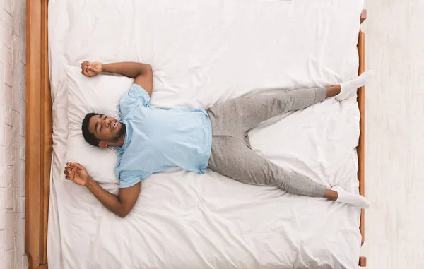 Jovem homem afro-americano dormindo na cama vista superior — Fotografia de Stock