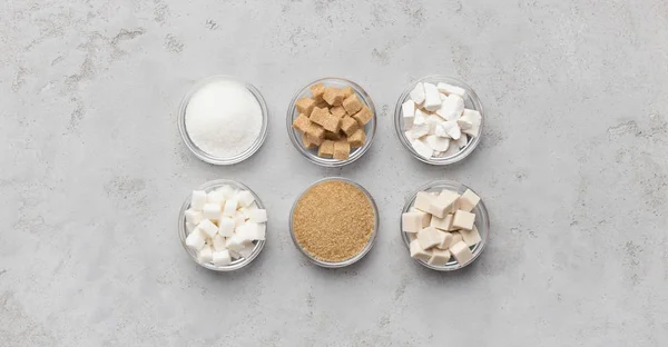 Coleção de diferentes tipos de açúcar no fundo cinza — Fotografia de Stock