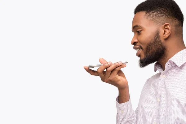 Hombre negro usando asistente de voz en el teléfono móvil — Foto de Stock