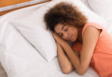 Evde yatağında uyuyan Afrikalı-Amerikalı kadın