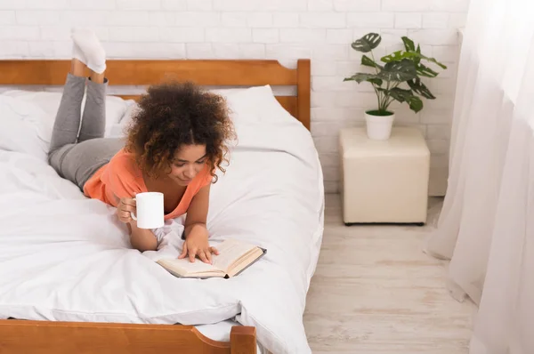 Chica afroamericana leyendo libro y tomando café —  Fotos de Stock