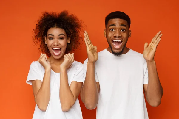 Joyful mulher negra e homem gritando no fundo laranja — Fotografia de Stock