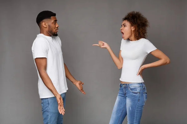 Angry woman standing and blaming at unhappy man — Stock Photo, Image