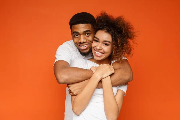 Молодая прекрасная африканско-американская пара позирует на оранжевом фоне — стоковое фото