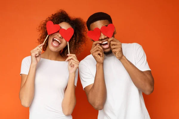 Junges Paar mit roten Liebesherzen über den Augen — Stockfoto