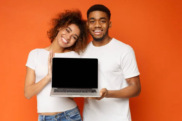 Jeune couple noir tenant ordinateur portable avec écran vierge — Photo