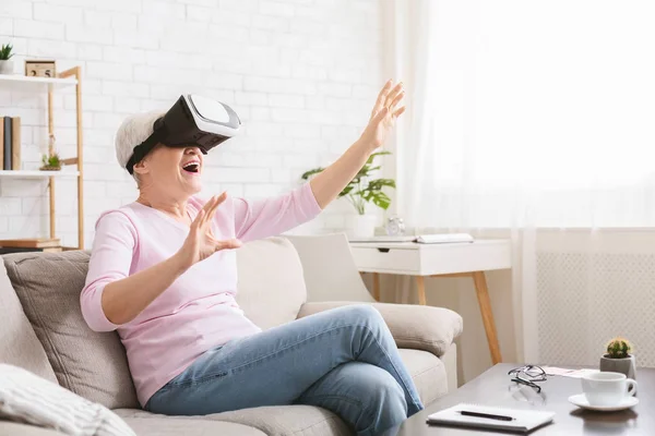 Mujer mayor moderna usando gafas VR en casa — Foto de Stock