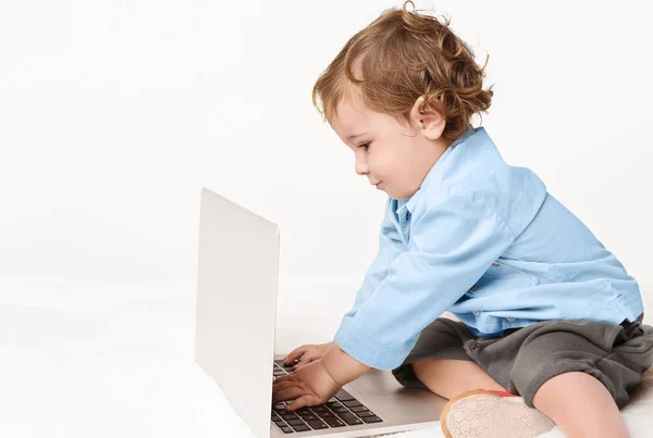 Bonito menino digitando no teclado do laptop — Fotografia de Stock