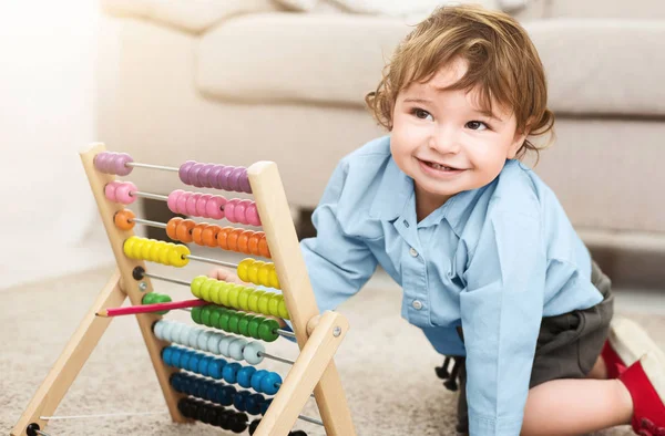 Schattig babyjongen spelen met kleurrijke scores thuis — Stockfoto