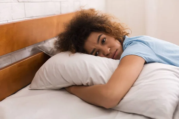 Беспокойная девушка обнимает подушку и унылые мысли — стоковое фото