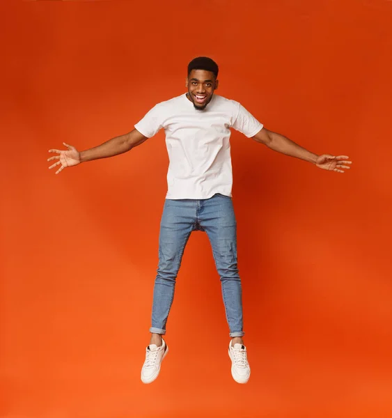 Смішний молодий чорний чоловік стрибає в повітрі — стокове фото
