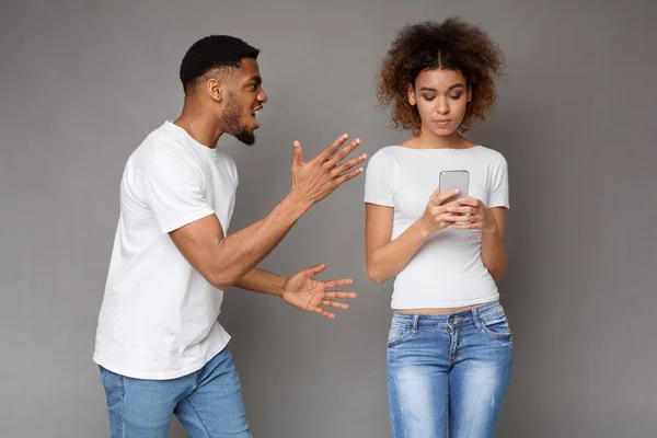 Černá žena pomocí telefonu, přítel na ni křičet — Stock fotografie