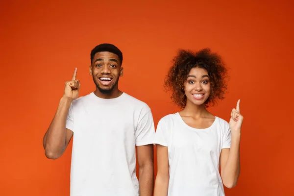 Vrolijke man en vrouw wijs wijsvinger omhoog — Stockfoto