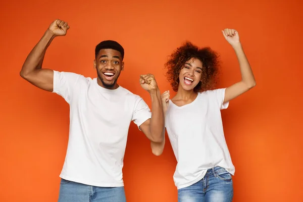 African-american partners rejoice success together on orange background — Stock Photo, Image