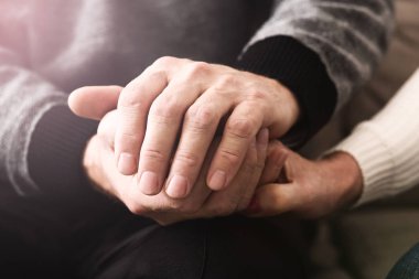 Sevgi ve destek. Yaşlı insanlar şefkatle el ele tutuşur