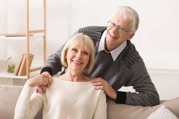 Romantic senior couple smiling happily at camera — Stock Photo, Image