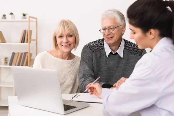 Elderly couple discussing treatment plan with doctor — Stock Photo, Image