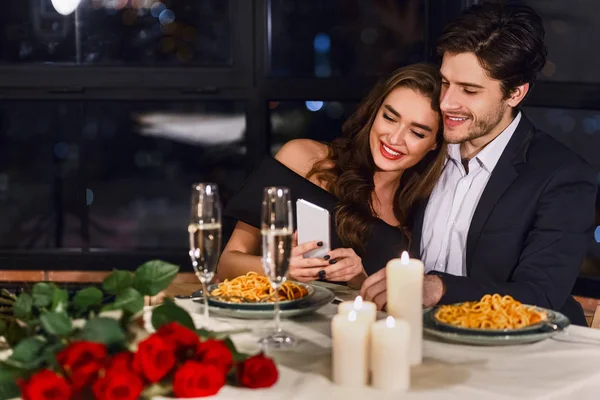 Pareja feliz usando smartphone en restaurante — Foto de Stock