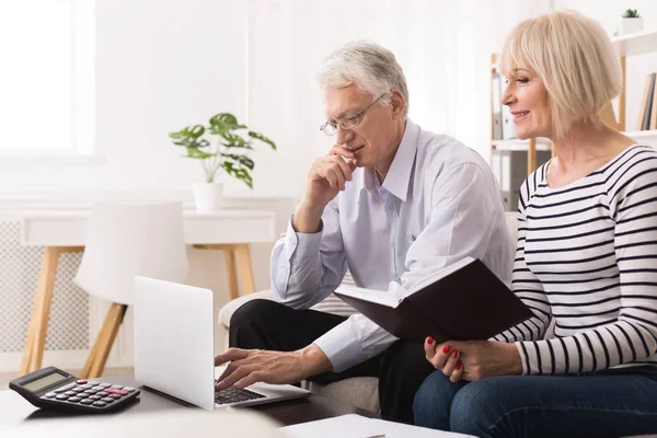 Älteres Ehepaar prüft seine Rechnungen am Laptop — Stockfoto