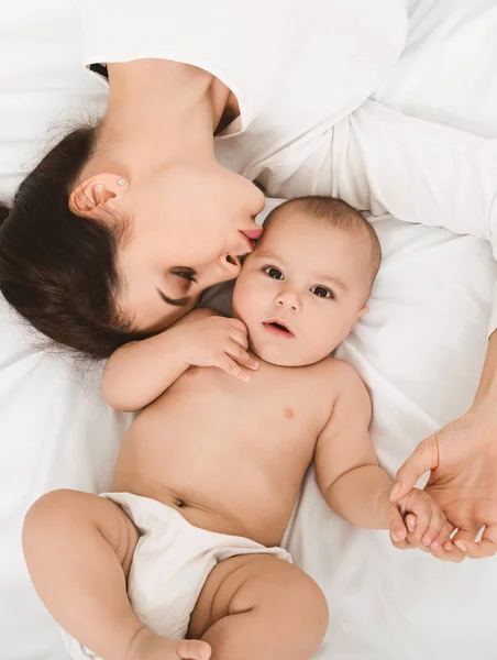 Mutlu anne ve bebek yatakta yatarken görünümü top — Stok fotoğraf