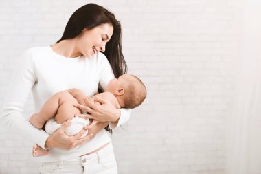 Genç Anne şirin yeni doğmuş çocuğunu sarılma