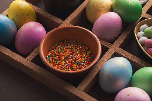 Bunte Eier und Streusel auf dunklem Hintergrund — Stockfoto