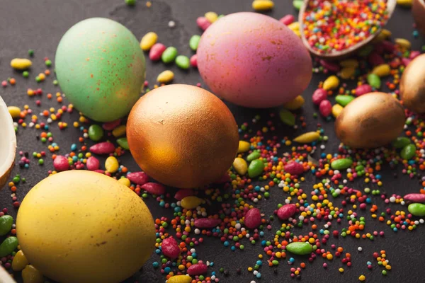 Gefärbte Eier und verstreute Bonbons — Stockfoto