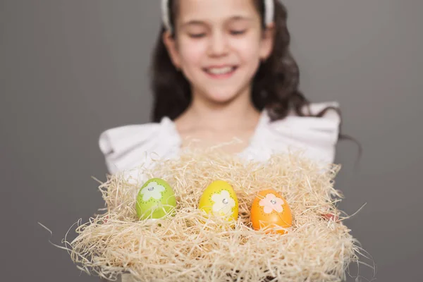 Menina bonito com segurando brilhantes ovos de Páscoa — Fotografia de Stock