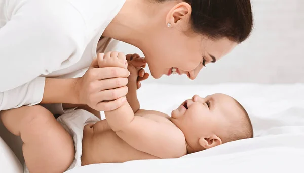 Mamma leker med hennes baby i sovrum. — Stockfoto