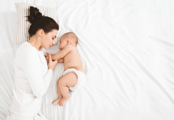 Tânără mamă și copilul ei drăguț dormind în pat — Fotografie, imagine de stoc