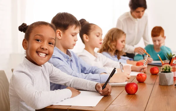 Schoolkinderen test in klas schrijven met de leerkrachten helpen — Stockfoto
