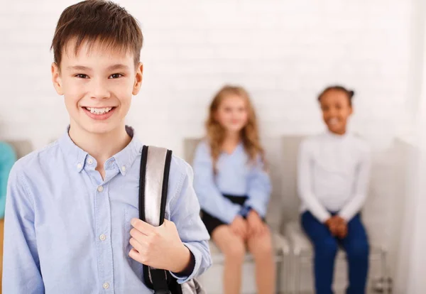 Gelukkige jongen rugzak uitvoering en permanent in de klas — Stockfoto