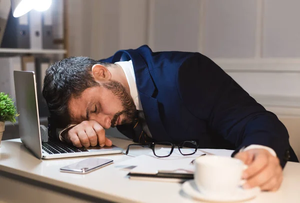 Trött affärsman sover på laptop på kontoret — Stockfoto